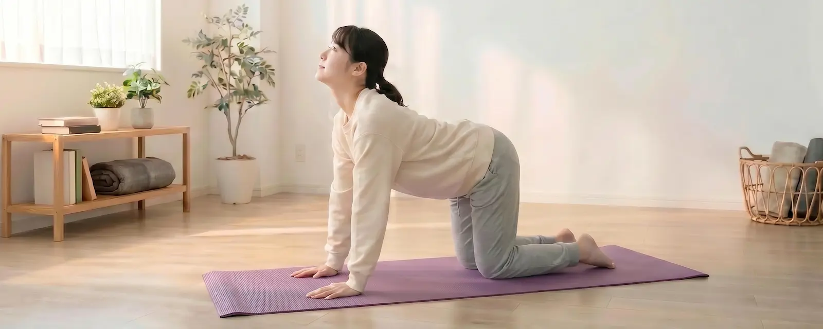 四つん這いで背骨・肩甲骨をほぐすストレッチをする女性